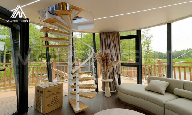 Transparent first floor living area with glass walls in glamping tent