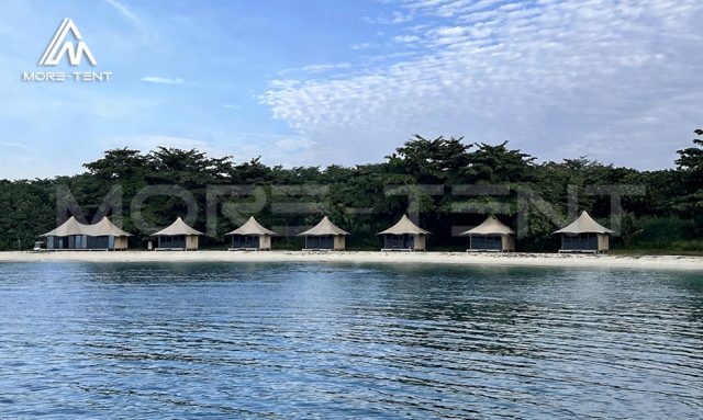 Panoramic view from the sea of safari tent suites along the resort coastline