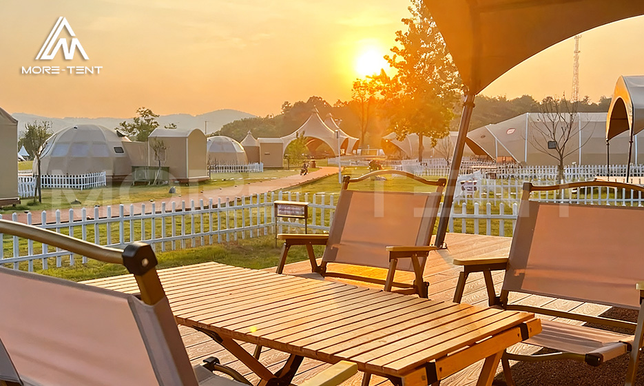 Wooden terrace of a glamping campsite glowing at sunset