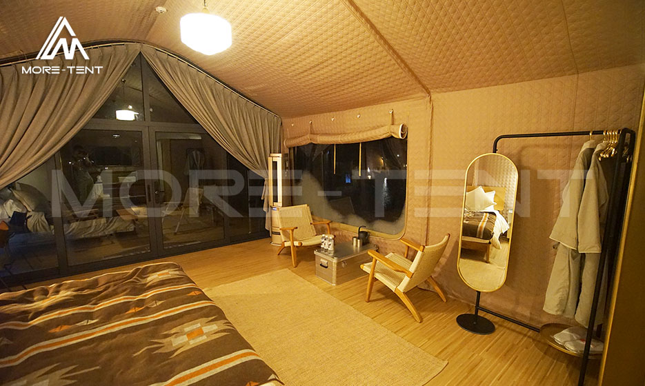 Glamping tent interior with lounge seating and large window view