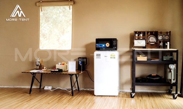 Kitchenette corner with refrigerator and microwave inside a safari tent suite