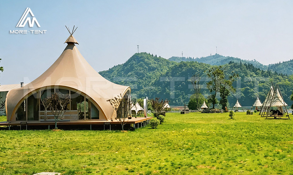 Tipi glamping tent with a pointed roof on a green lawn