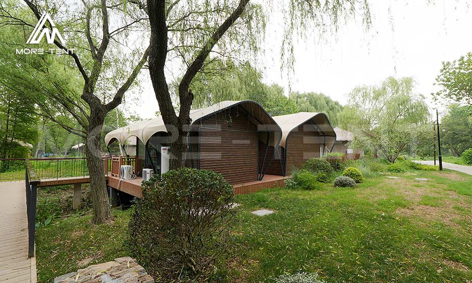 Durable glamping tent cabins with wood walls in a forest resort