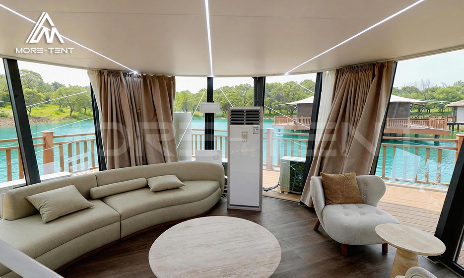 Glamping tent lounge with comfortable seating and a panoramic lake view