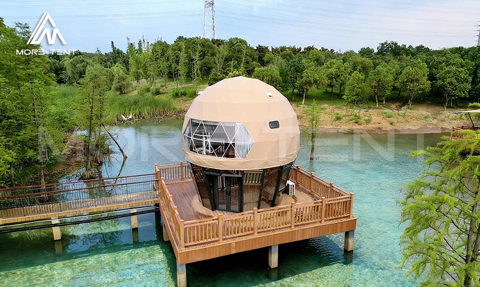 Luxury dome glamping tent on a private deck over clear water