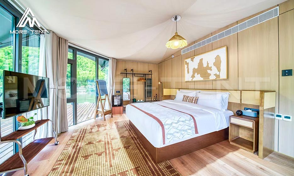 Luxury glamping tent hotel bedroom with modern furnishings and lake views