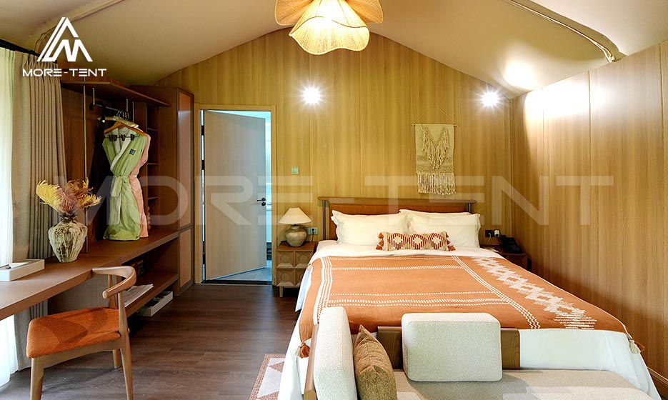 Finished glamping tent bedroom with built-in wood furnishings