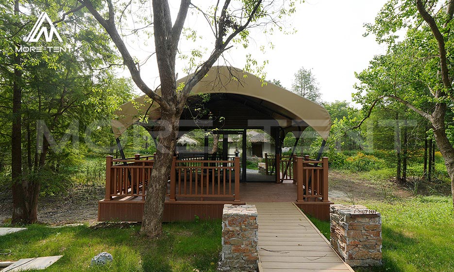 Prefabricated glamping tent cabin with a raised entrance deck